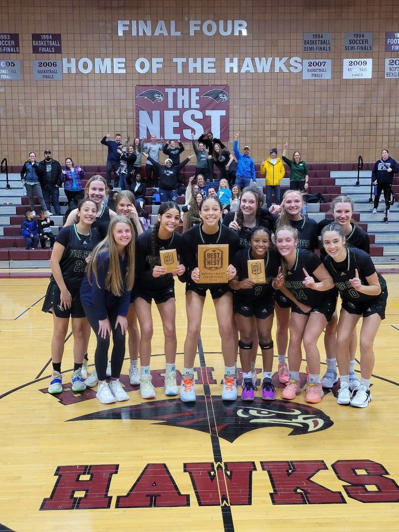 Girls Basketball players pose with winner's plaque 